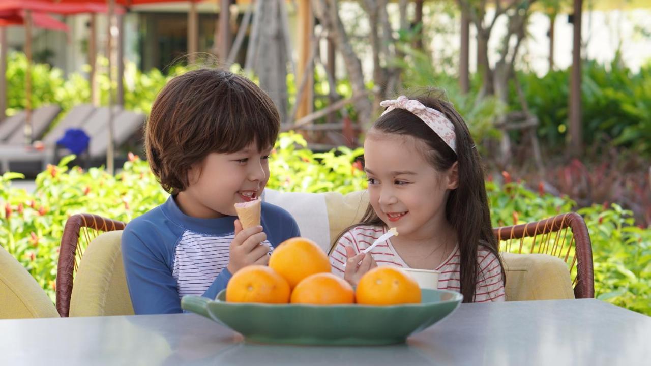 فندق Amari باتايا المظهر الخارجي الصورة A boy and a girl eating fruit